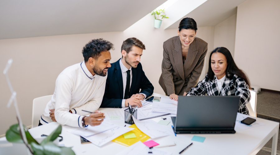 Business professionals gathered around a computer