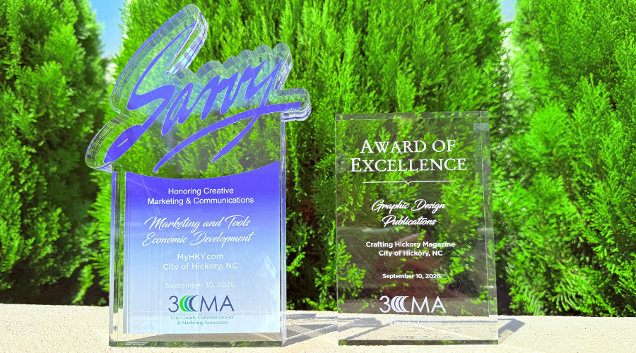 City of Hickory's two Savvy Awards sit in front of green bushes outside City Hall