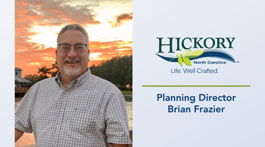 Planning Director Brian Frazier stands in front of a body of water and a sunset sky